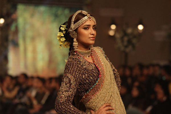 पाक डिज़ाइनर फहाद हुसैन की डिजाइन को पेश करती पाकिस्तानी मॉडल। (फ़ोटो-एपी)