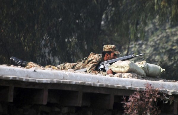 तालिबानी आतंकियों द्वारा कब्जे में लिए गए सैनिक स्कूल के नज़दीक सड़क के ऊपर मोर्चा संभाले हुए पाक सेना के जवान। (फ़ोटो-रॉयटर्स)