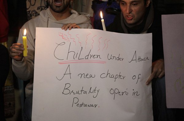 पेशावर के सैनिक स्कूल में मारे गए छात्रों के लिए प्रार्थना करते हुए पाकिस्तान सिवील सोसायटी के सदस्य। (फोटो: एपी)