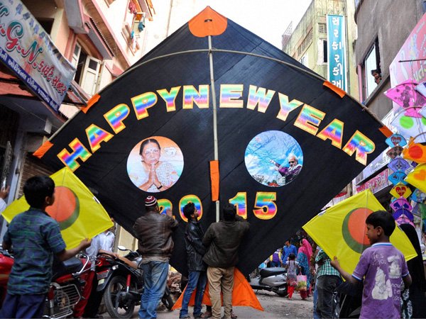 New Year 2015: अहमदाबाद में पतंग बनाने वाले कारीगर ने एक पतंग को न्यू ईयर ग्रीटिंग बनाया जिसमें प्रधानमंत्री नरेंद्र मोदी और गुजरात की मुख्यमंत्री आनंदीबेन पटेल के चित्र हैं। (फ़ोटो-पीटीआई)