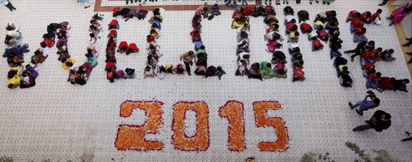 New Year 2015: अहमदाबाद के एक स्कूल में छात्रों ने नए साल का स्वागत करने के लिए 'वेलकम 2015' की रचना बनाई। (फ़ोटो-पीटीआई)