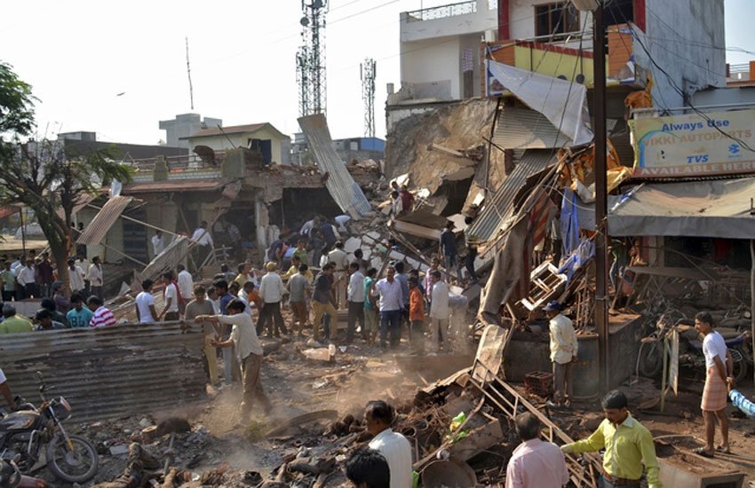 मध्य प्रदेश के झाबुआ जिले के पेटलावद कस्बे में शनिवार सुबह साढ़े आठ बजे एक रेस्टोरेंट व उसके पास स्थित इमारत में हुए विस्फोट में कम से कम 89 लोगों की मौत हो गई और 100 से ज्यादा लोग घायल हो गए। (पीटीआई फोटो)