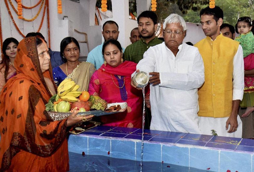 राजद अध्यक्ष लालू प्रसाद अपनी पत्नी राबड़ी देवी और परिवार संग पटना में मंगलवार को छठ पूजा के दौरान प्रार्थना करते हुए। (स्रोत-पीटीआई)