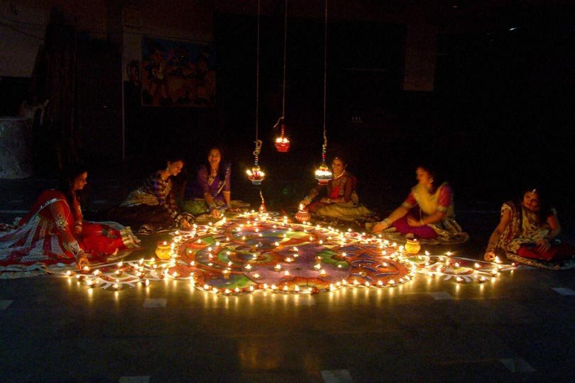 मंगलवार को दीपावली उत्सव के अवसर पर सूरत में महिलाएं रंगोली तैयार करती हुईं। (स्रोत-पीटीआई)