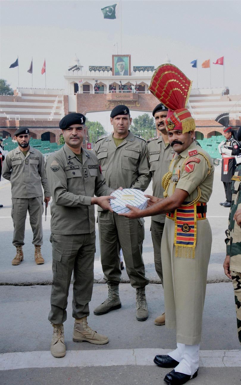 बुधवार को भारत-पाक के बीच अट्टारी-वाघा सीमा पर सीमा सुरक्षा बल के आधिकारी पाकिस्तानी रेंजरों को दीपावली के मौके पर मिठाई भेंट करते हुए। (स्रोत-पीटीआई)