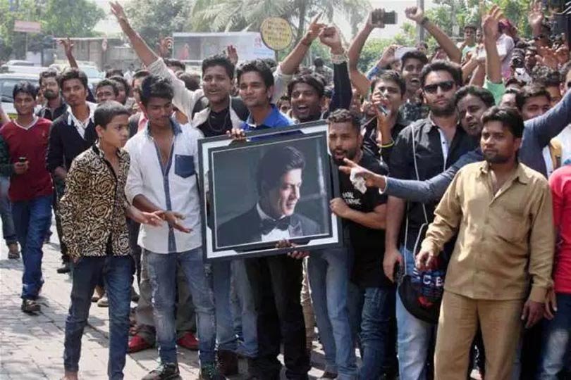 सोमवार को मुंबई में शाहरुख के घर 'मन्नत' के बाहर उनकी तस्वीर के साथ खड़े होकर शाहरुख को उनके जन्मदिन की शुभकामनाएं देते प्रशंसक। (स्रोत-पीटीआई) (स्रोत-फोटो वरिंदर चावला)