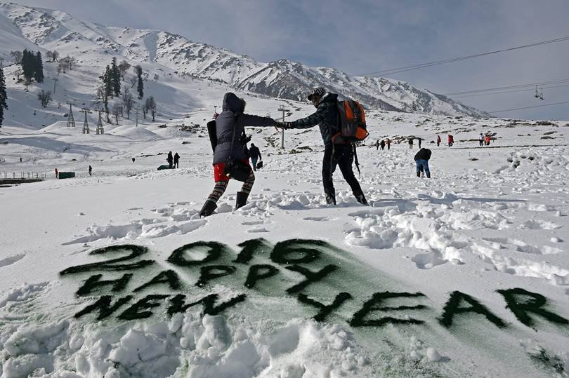 गुलमर्ग के स्की रिसोर्ट कंगडूरी में नए साल के स्वागत में पर्यटक बर्फ से स्नो कैप्ट मैडोज़ बनाते हुए। (पीटीआई)