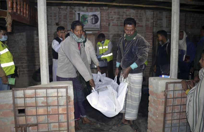 फिदायीन हमले में मारे गए एक संदिग्ध के शरीर को लाते बांग्लादेशी नादरिक। (एपी फोटो) 