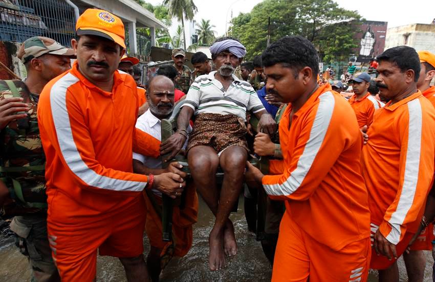 चेन्नई में बाढ़ प्रभावित क्षेत्र से बुजुर्ग को बाहर निकालते राष्ट्रीय आपदा प्रबंधन दल के सदस्य। फोटो-एजेंसी