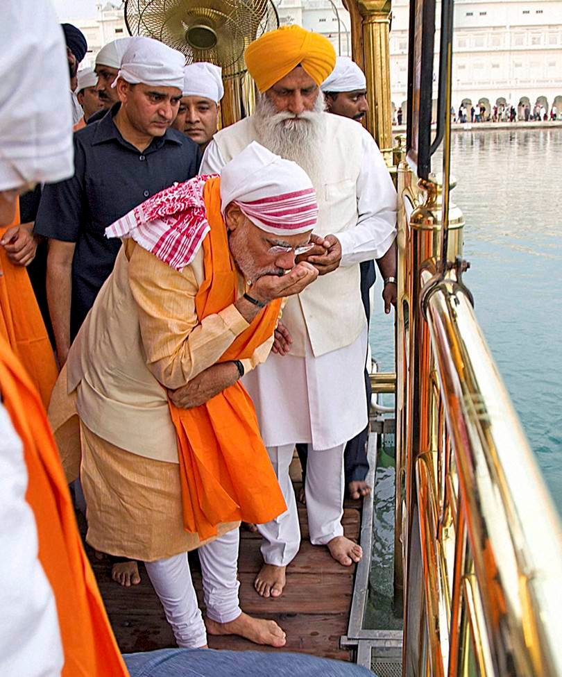 प्रधानमंत्री नरेंद्र मोदी अमृतसर दौरे के दौरान स्वर्णमंदिर में पूजा के बाद सरोवर से पवित्र जल पीते हुए।
