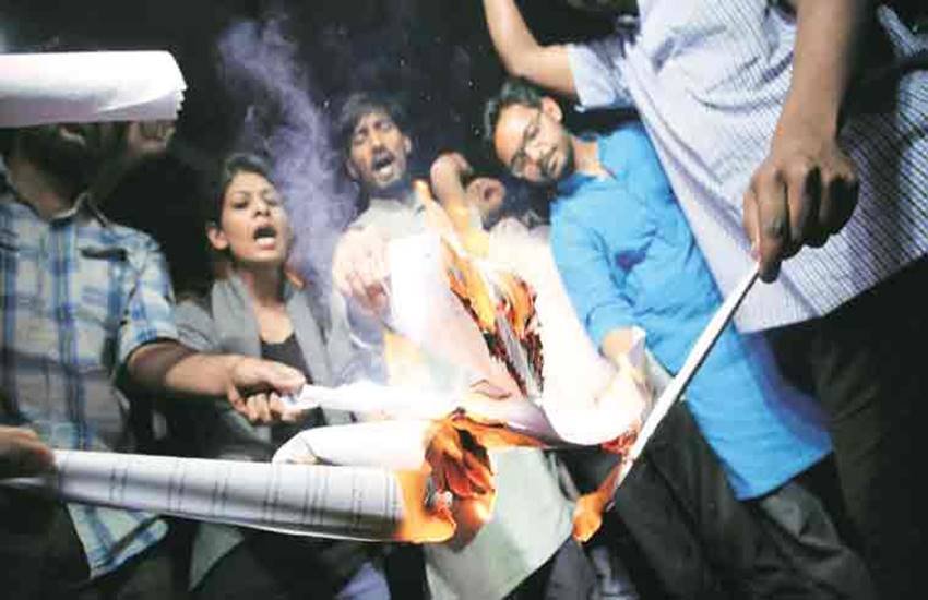 मनुस्मृति को जलाते एबीवीपी और एनएसयूाई के सदस्य