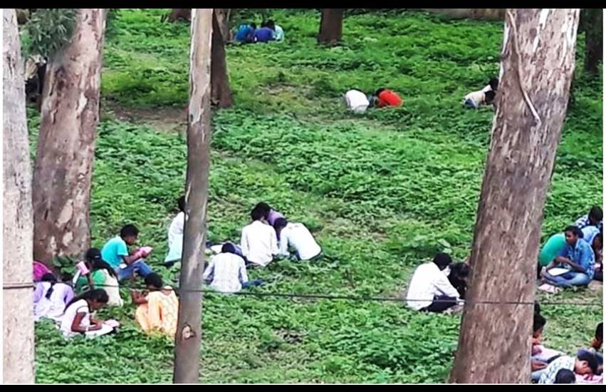 छात्रों को परीक्षा के लिए किसी क्लास रूम में नहीं बल्कि फील्ड में बैठाया गया।