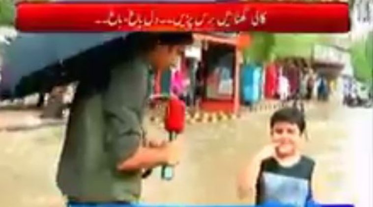 रिपोर्टर बच्चे से पूछता है कि वह इस बारिश में यहां क्या कर रहा है? (Photo Source: Screenshot)