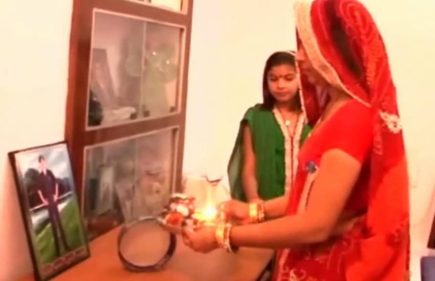 शहीद पति की तस्वीर की पूजा करतीं पत्नी। (Photo-ANI/Video)