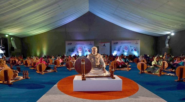 Ludhiana: Prime Minister Narendra Modi works at a charkha at a ceremony to distribute charkhas to women before the National MSME Awards at Punjab Agricultural University in Ludhiana on Tuesday. PTI Photo / PIB (PTI10_18_2016_000192B)