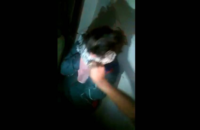 आरोपी महिला के चेहरे से दुपट्टा हटाता एक युवक। (Video Screenshot)