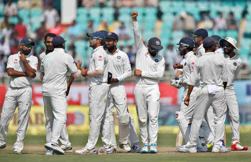विशाखापत्तनम में खेले गए दूसरे टैस्ट मैच में इंग्लैंड के खिलाफ जीत के बाद साथी खिलाड़ियों के मध्य भारतीय टीम के कप्तान विराट कोहली हाथ उठाकर जीत का जश्न मनाते हुए। (AP Photo/Aijaz Rahi/21 Nov, 2016) 