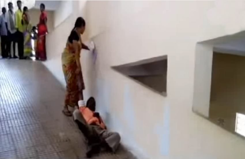 स्ट्रेचर नहीं मिलने पर पति को घसीटकर ले गई महिला। (Photo Source: Videograb)
