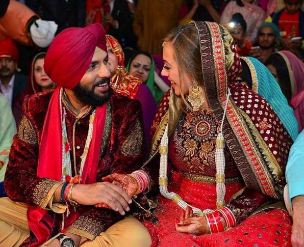 शादी की एक रस्म के दौरान एक दूसरे से बाद करते युवी और हेजल