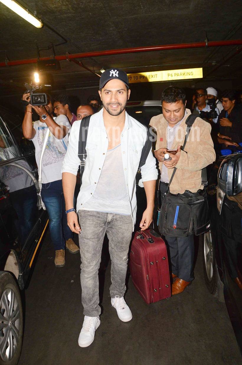 तस्वीरें क्लिक करवाने के लिए स्माइल करते वरुण धवन