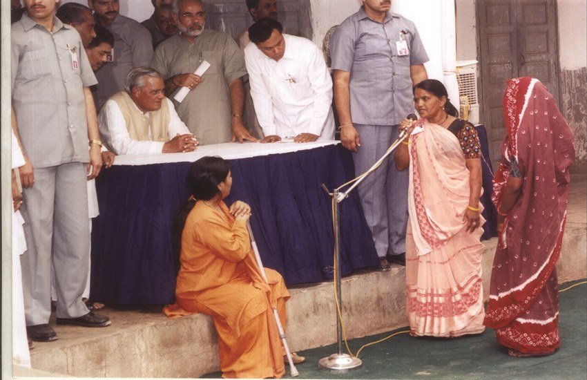 गोधरा दंगों के बाद पीड़ितों से मिलते तत्कालीन प्रधानमंत्री अटल बिहारी वाजपेयी। साथ में नरेन्द्र मोदी (पीछे खड़े) और उमा भारती (नीचे बैठी हुईं)। (फोटो- एक्सप्रेस आर्काइव)