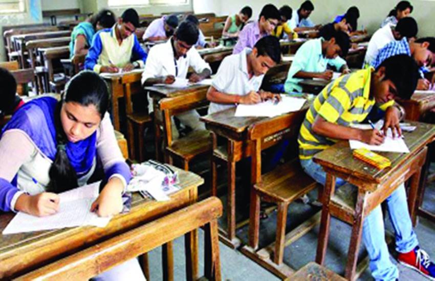 परीक्षा हॉल में परीक्षा देते छात्र।