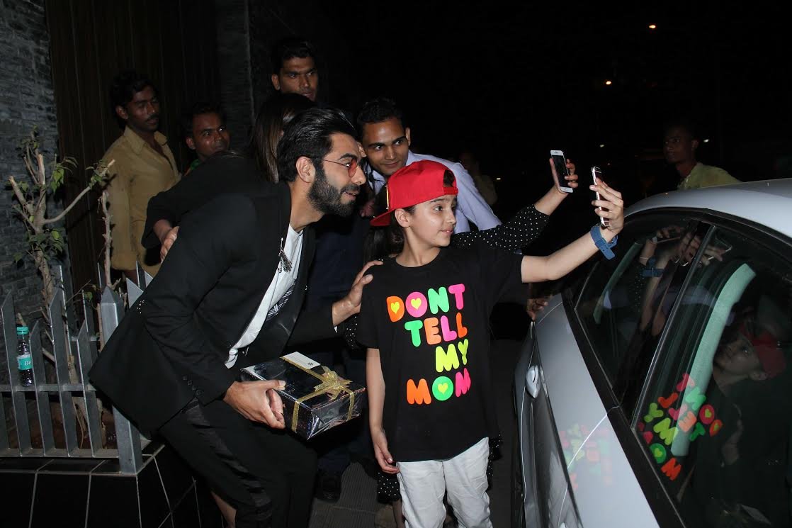 अपारशक्ति खुराना के साथ तस्वीर क्लिक करवाता एक बच्चा।