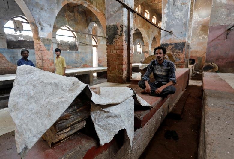 लखनऊ के बंद पड़े मटन मार्केट में खाली बैठा एक शख्स। (REUTERS/Pawan Kumar)