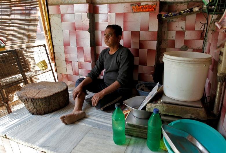 इलाहाबाद में एक मीट दुकानदार अपनी दुकान पर खाली बैठा हुआ। (REUTERS/Jitendra Prakash)