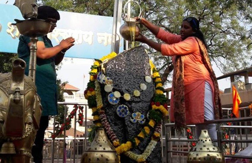 शनि देव की मूर्ति पर तेल चढ़ाती महिलाएं। ( Photo Source: Indian Express)