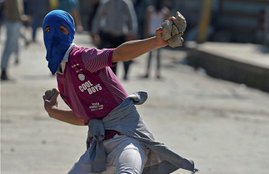 Srinagar A youth throws a stone on security force personnel
