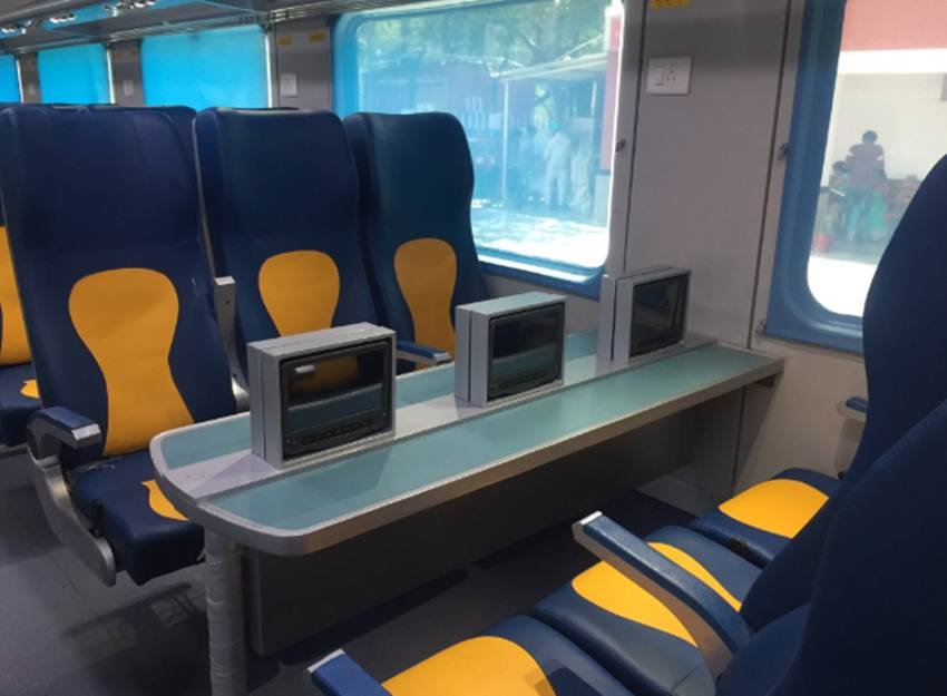 इस ट्रेन में यात्रियों को कई सुविधाएं दी जा रही हैं। ट्रेन में एलसीडी स्क्रीन्स दी गई हैं। इन पर यात्री फिल्में भी देख सकेंगे और पैसेंजर लिस्ट भी देख सकेंगे। (Photo Source: Financial Express/Youtube Video Grab)
