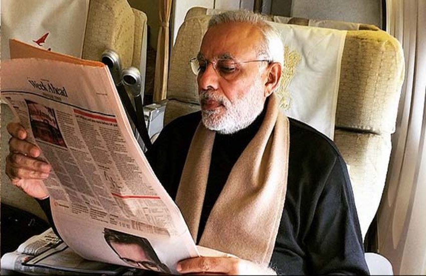 विमान में अखबार पढ़ते हुए प्रधानमंत्री नरेंद्र मोदी। (फोटो सोर्स इंस्टग्राम)