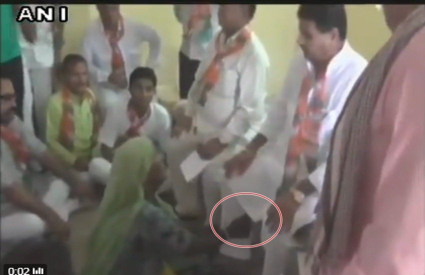 राजस्थान के मंत्री का पैर पकड़ कर गिड़गिड़ाती महिला। (फोटो-ANI)