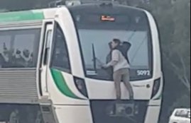 A man hitches a lift by clinging, man clinging train's windscreen wipers as it speeds along the tracks at 70mph, man clinging train's windscreen speeds along the tracks at 70mph