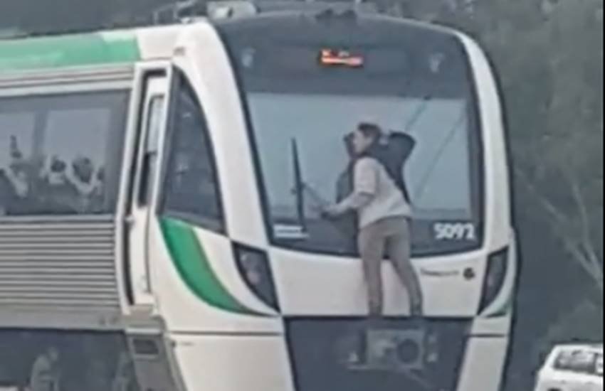 A man hitches a lift by clinging, man clinging train's windscreen wipers as it speeds along the tracks at 70mph, man clinging train's windscreen speeds along the tracks at 70mph