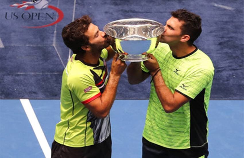 मैच जीतने के बाद जीन-जूलियन रोजेर और होरिया टेकाउ। (Photo Courtesy : AFP)