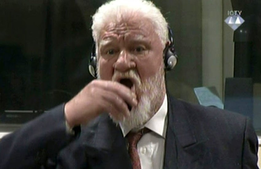 फैसले के बाद जनरल प्रालजैक खड़े हुए और अपना हाथ मुंह पर लगा लिया, सिर पीछे किया। (Photo: Reuters)