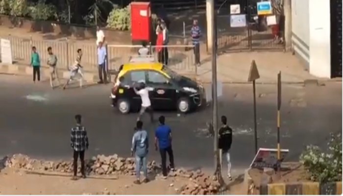 सड़क पर जा रही कारों पर हमला करता एक युवक।