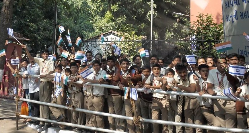 रोड शो के दौरान हाथ में भारत और इजरायल का झंडा लिए खड़े बच्चे।