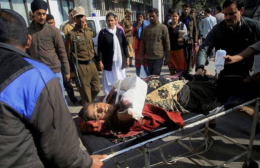 जम्‍मू के हीरानगर में पाकिस्‍तानी गोलीबारी में घायल महिला को अस्‍लपताल ले जाते लोग। (फोटो सोर्स: पीटीआई)