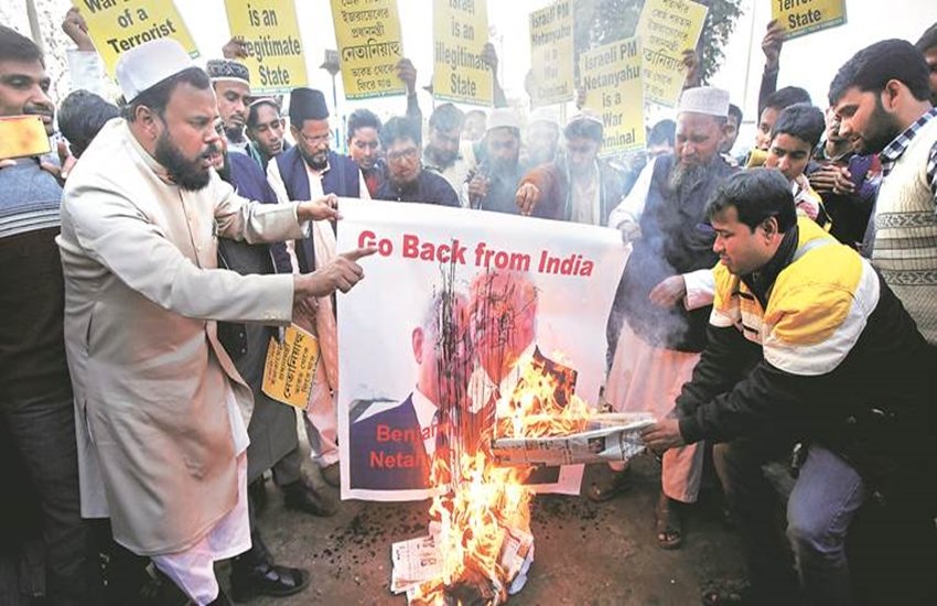 विरोध प्रदर्शन के दौरान बेंजामिन नेतन्याहू और डोनाल्ड ट्रंप के पोस्टर को जलाते हुए प्रदर्शनकारी। (फोटो सोर्स- एपी)