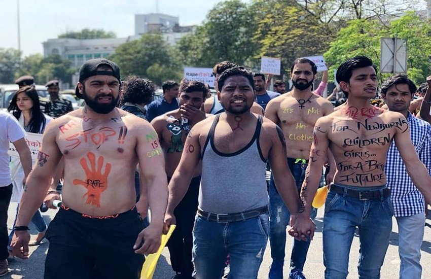 इन लड़कों ने बोर्ड्स और प्लेकार्ड्स लेकर मंडी हाउस से सेंट्रल पार्क तक मार्च निकाला, जिन पर लिखा था - "उसके कपड़े छोटे नहीं, छोटी तुम्हारी सोच है" और "आठ महीने की बच्ची ने कौन-से छोटे कपड़े पहने, जो उसके साथ रेप हुआ।" (Photo Source: Facebook)