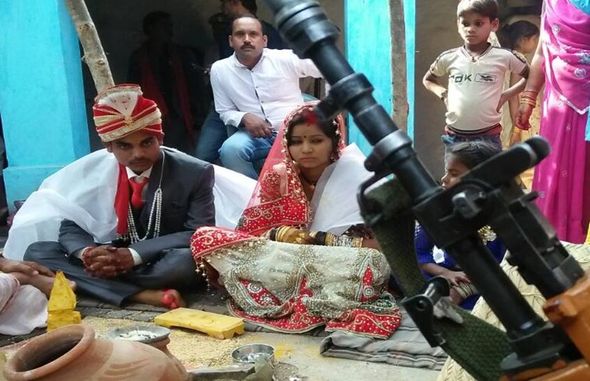 मध्य प्रदेश के छतरपुर जिले के गुलगंज थाना क्षेत्र के अंतर्गत आने वाले गांव मौखेरा में कुछ दबंगों पर एक शादी में व्यवधान डालने और दूल्हा-दुल्हन समेत उनके परिवार को पीटने का आरोप लगा है। बुंदेलखंड में लगने वाले गांव के विश्वकर्मा परिवार में शादी चल रही थी। विवाद इतना बढ़ गया कि बाद में पुलिस के पहरे और बंदूकों के साये में शादी हो सकी। दुल्हन के परिवार की तरफ से पुलिस में शिकायत दर्ज कराई गई। पुलिस में दर्ज शिकायत के मुताबिक गांव के मंगल सिंह, पुष्पेंद्र सिंह और गोलू सिंह पर मारपीट के आरोप लगे हैं। आरोपी फरार चल रहे हैं और पुलिस उनकी तलाश में दबिश दे रही है। दुल्हन ने मीडिया को बताया कि गांव के ठाकुरों के घर उसके परिवार के लोग काम करने नहीं जाते थे, इसलिए उन्होंने उन्हें मारा। दुल्हन ने बताया कि दबंग सीधे घर के अंदर तक घुसे चले आए और उसके, पति और भाई समेत कई लोगों के साथ मारपीट की। (फोटो - केआर चौरसिया)