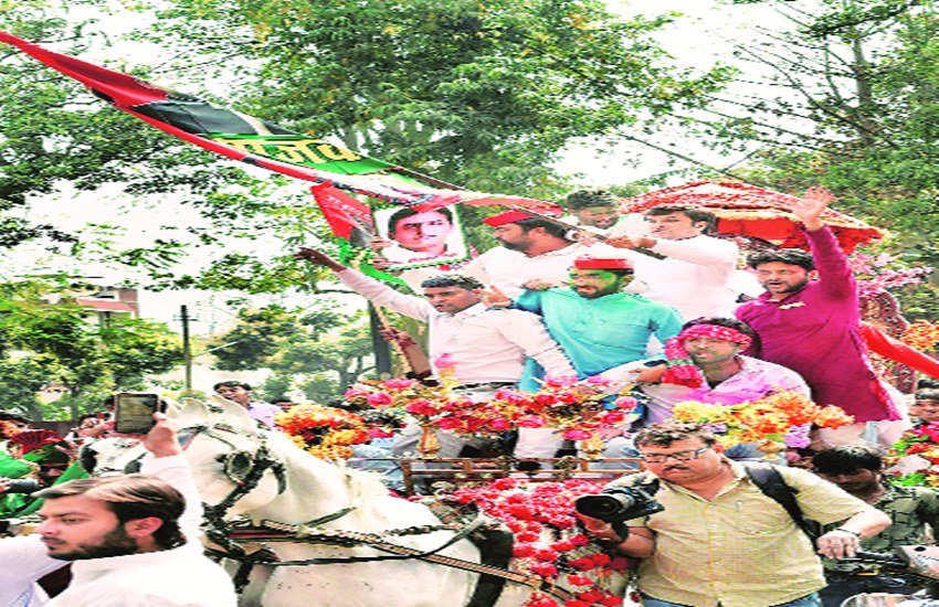 लखनऊ में सपा मुख्यालय पर उपचुनाव में जीत के बाद जश्न मनाते कार्यकर्ता।