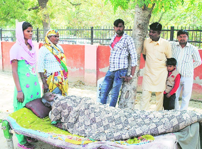 जिलाधिकारी कार्यालय के बाहर घर के बीमार मुखिया को लेकर आए उसके परिजन।