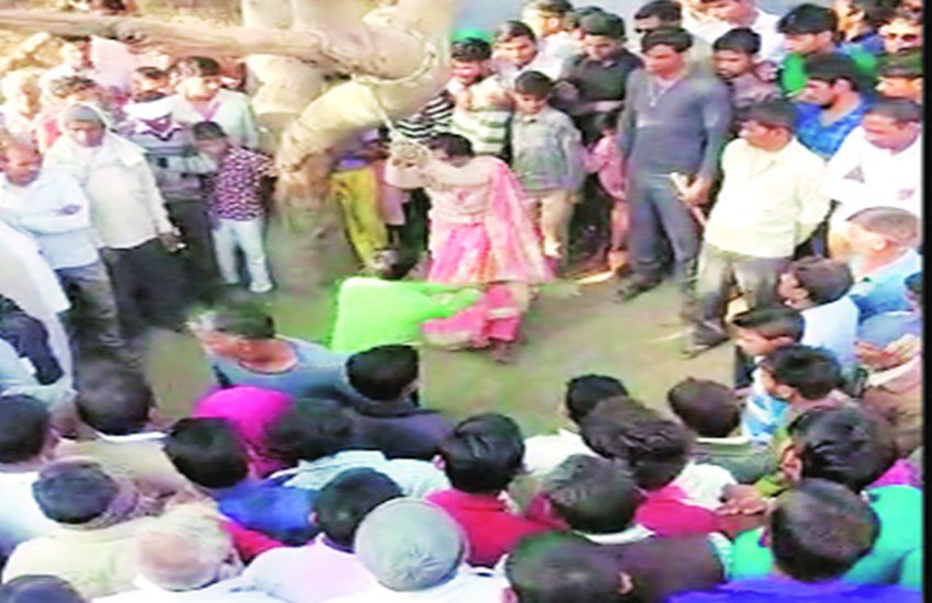 पेड़ से बांधकर महिला की पिटाई करता पति और मौजूद चश्मदीद।