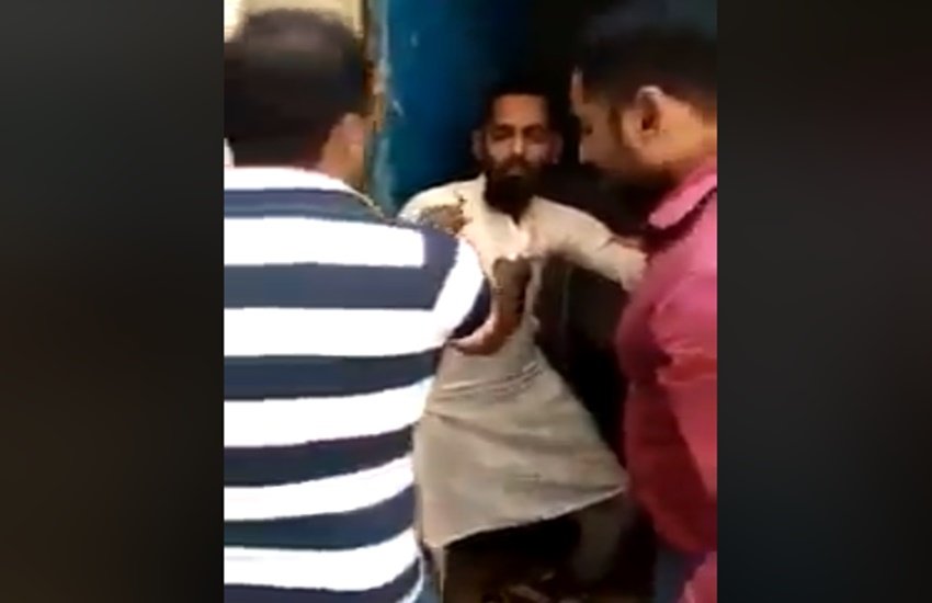 मौलवी को पीटते हुए छात्रों के परिजन। (Photo Source: Viral video Grab)