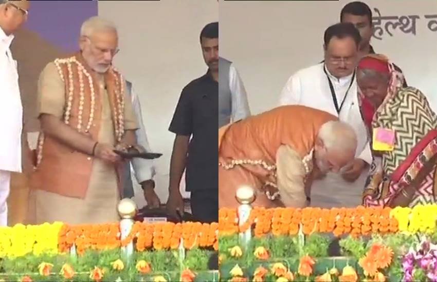 पीएम नरेंद मोदी ने आदिवासी महिला को पहनाईं नई चप्पलें। (फोटो सोर्स - एएनआई)