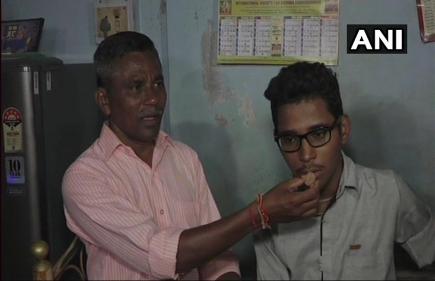 बेटे शिवम को सफलता की बधाई देते पिता मुकेश सोलंकी। फोटो- ANI 